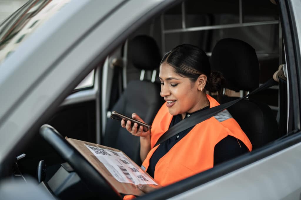 Certified medical courier using a phone in the process of delivering lab results