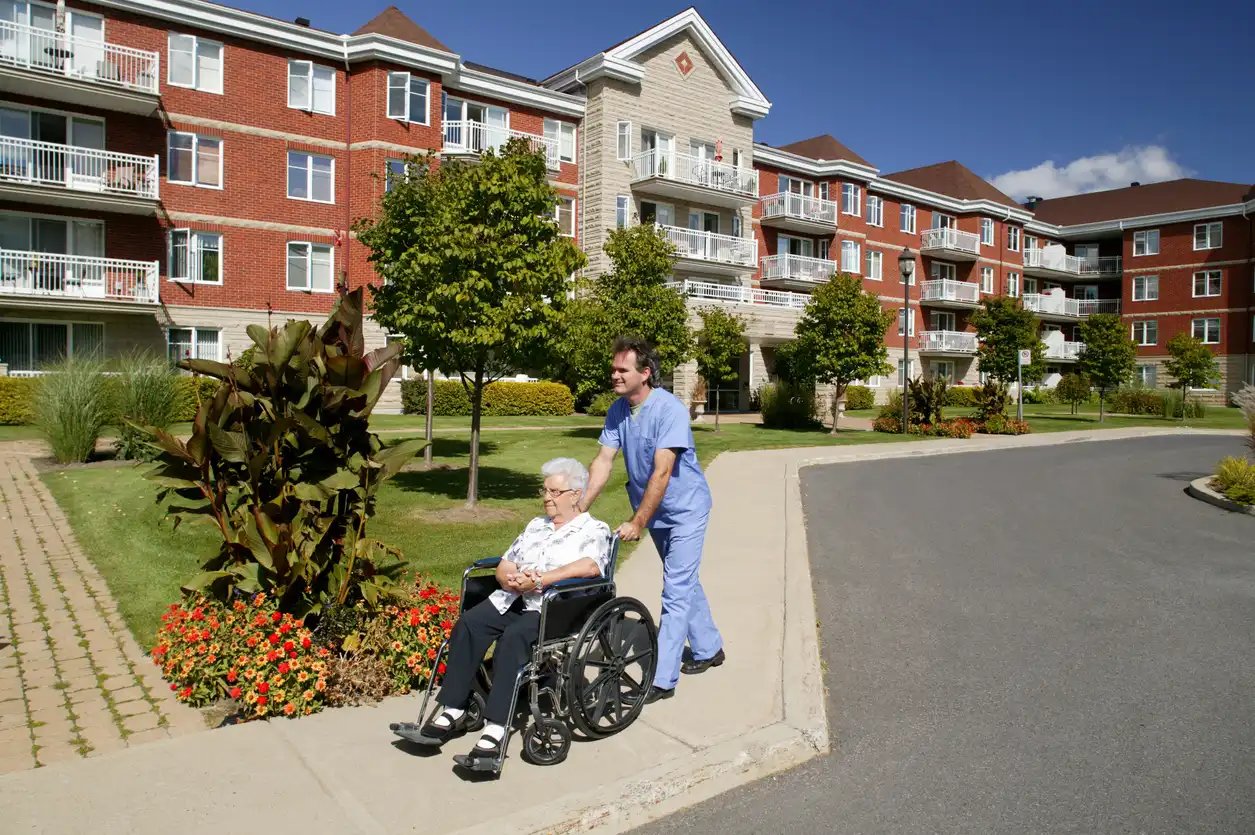 Nursing home with a nurse pushing a patient in a wheel chair