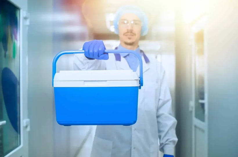 man in lab coat holding cooler