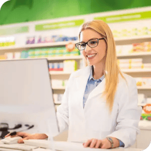 female pharmacist standing at counter computer