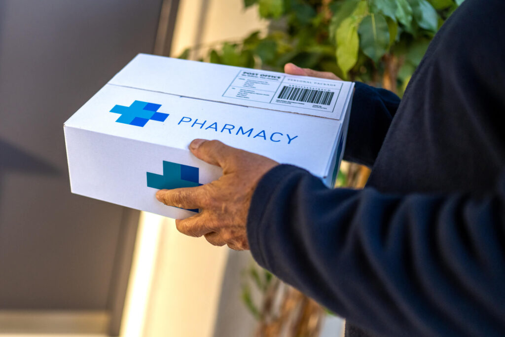 Close-up view of delivery man in blue uniform organizing packages before handing package to customers